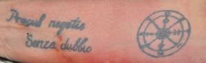 Na zdjęciu tatuaż w postaci napisu w języku łacińskim o treści &quot;procul negotis senza dubbio&quot; oraz koła marynarskiego.