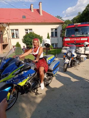 Na zdjęciu policyjny motocykl, na którym siedzi kobieta.