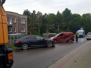 Na zdjeciu pojazdy jakie brały udział w zdarzeniu drogowym w Błażowej. W tyle radiowóz i umundurowany policjant.