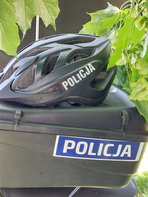 Ns zdjęciu kask rowerowy z napisem policja.