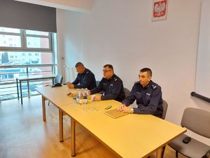 Na zdjęciu siedzą: pośrodku Komendant Miejski Policji w Rzeszowie inspektor Bogusław Kania, z jego prawej strony I Zastępca Komendanta Miejskiego Policji w Rzeszowie mł. insp. Marek Worek, po lewej stronie  Zastępca Komendanta Miejskiego Policji w Rzeszowie mł. insp. Wacław Sudoł.