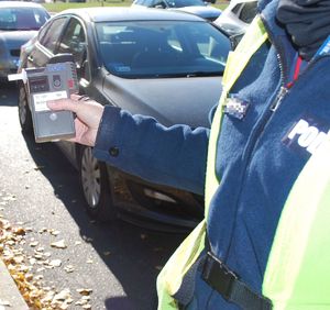 Na zdjęciu policjant z urządzeniem do badania stanu trzeźwości.