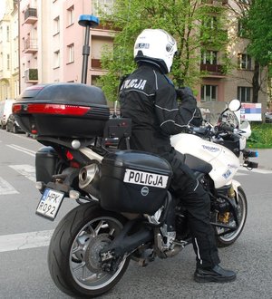 Na zdjęciu siedzący na służbowym motocyklu umundurowany policjant ruchu drogowego.