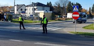 Na zdjeciu umundurowani policjanci  ręcznie kierują ruchem na skrzyżowaniu.