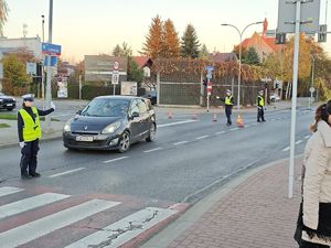 Na zdjęciu troje umundurowanych policjantów ruchu drogowego ręcznie sterujących ruchem.