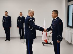 Na zdjęciu p.o. I Zastępcy Komendanta Miejskiego Policji w Rzeszowie mł. insp. Rafał Dryś wita się z p.o. Komendanta Miejskiego Policji w Rzeszowie mł. insp. Markiem Pietrykowskim. W tle policjantka i policjanci komendy miejskiej.