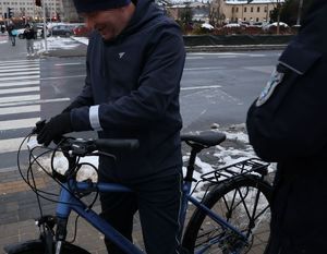 Na zdjęciu umundurowany policjanta i rowerzysta z rowerem.