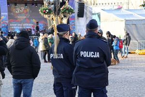 Na zdjeciu dwoje umundurowanych policjantów stojących tyłem.