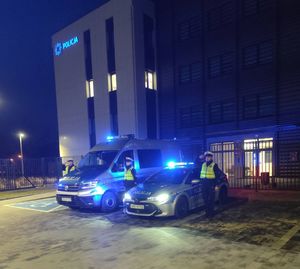 Na zdjęciu Komisariat Policji II w Rzeszowie. Przed komisariatem stoją dwa radiowozy w włączonymi światłami uprzywilejowania. Po Lewej i prawej stronie radiowozów stoją umundurowani policjanci w postawie zasadniczej, oddają hołd.
