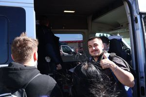 Na zdjęciu śmiejący się chłopak z kciukiem wyciągniętym do góry.
