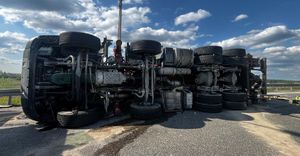 Na zdjęciu przewrócona na prawy bok ciężarówka.