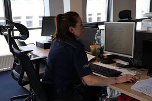 Na zdjęciu umundurowana policjantka siedzi przy biurku.