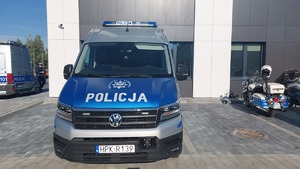 Na zdjęciu policyjna furgonetka i motocykl.