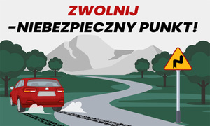 Na zdjęciu napis zwolnij niebezpieczny punku, poniżej kręta droga po której jedzie czerwone auto.