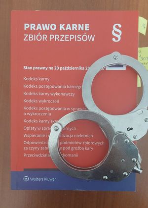 Na zdjęciu kodeks karny na którym leza kajdanki.
