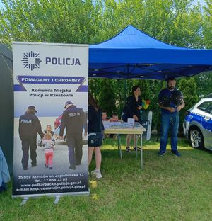 Na zdjęciu stoisko profilaktyczne Komendy Miejskiej Policji w Rzeszowie, namiot , rollup i policyjny radiowóz.