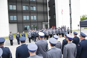 Na zdjęciu od tyłu kadra kierownicza KMP w Rzeszowie, przodem stoją awansowaniu funkcjonariusze.