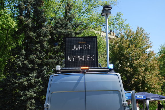 Na zdjęciu policyjny ambulans ruchu drogowego z wysuniętą tablica świetlną informującą o wypadku  drogowym.