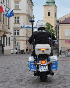 Na zdjęciu siedzący tyłem na motocyklu służbowym policjant w pełnym umundurowaniu, w kasku na głowie.