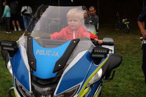 Na zdjęciu policyjny motocykl, na którym siedzi chłopiec.