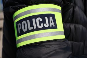 Na zdjęciu naramienna opaska odblaskowa z napisem policja.