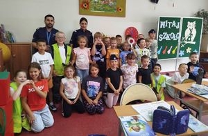 Na zdjęciu dwoje umundurowanych policjantów w szkolnej sali z uczniami.