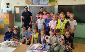 Na zdjęciu dwoje umundurowanych policjantów w szkolnej sali z uczniami.