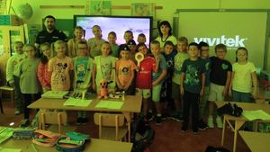 Na zdjęciu dwoje umundurowanych policjantów w szkolnej sali z uczniami.