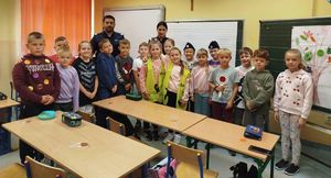 Na zdjęciu dwoje umundurowanych policjantów w szkolnej sali z uczniami.