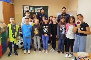 Na zdjęciu dwoje umundurowanych policjantów w szkolnej sali z uczniami.