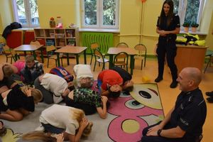 Na zdjęciu dwoje umundurowanych policjantów w szkolnej sali z uczniami.