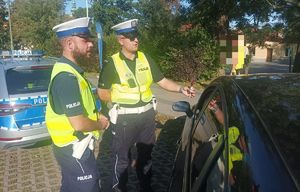 Na zdjeciu dwóch umundurowanych policjantów ruchu drogowego.