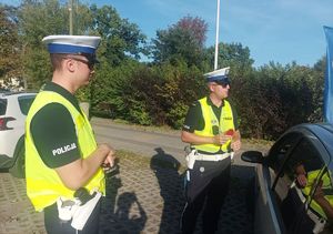 Na zdjeciu dwóch umundurowanych policjantów ruchu drogowego.