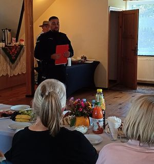 Na zdjęciu umundurowany policjant na spotkaniu z seniorami.