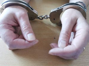 Na zdjęciu ręce z założonymi kajdankami.