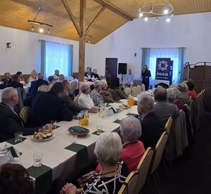 Na zdjęciu umundurowana policjantka na spotkaniu z seniorami.