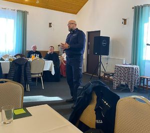 Na zdjęciu umundurowany policjant na spotkaniu z seniorami.