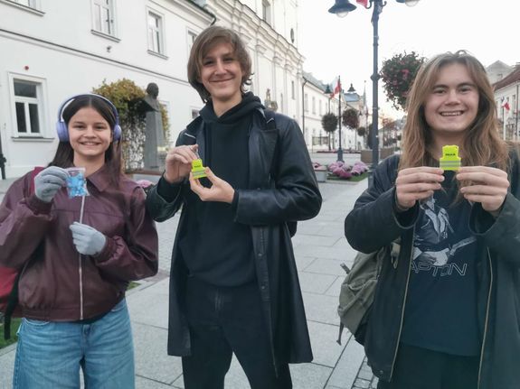 Na zdjeciu młodzież z odblaskami.