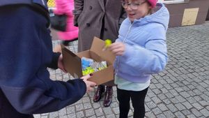 Na zdjęciu policjanci rozdają przechodniom odblaski.