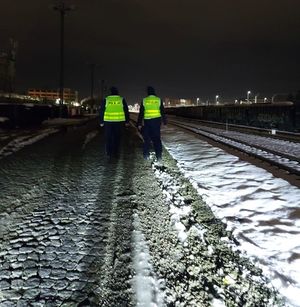 Na zdjęciu umundurowani policjanci w żółtych kamizelkach odblaskowych z napisem policja na plecach.