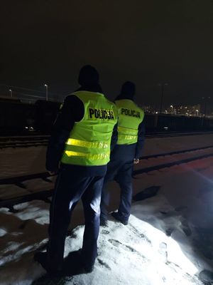 Na zdjęciu umundurowani policjanci w żółtych kamizelkach odblaskowych z napisem policja na plecach.