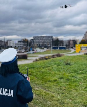 Na zdjęciu umundurowana policjantka ruchu drogowego obsługuje drona.