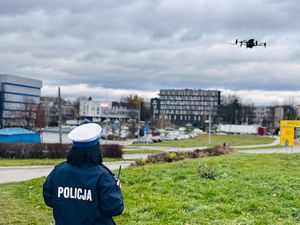 Na zdjęciu umundurowana policjantka ruchu drogowego obsługuje drona.