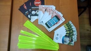 Na zdjęciu ulotka bezpieczny senior, fałszywy telefon i opaski odblaskowe.