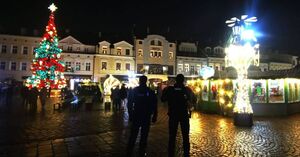 Na zdjęciu umundurowani policjanci, w tle Miasteczko Bożonarodzeniowe.