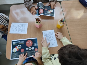 Na zdjęciu dzieci kolorujące kartki.