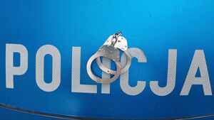 Na zdjęciu policyjne kajdanki leżące na masce radiowozu.