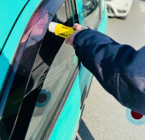 Na zdjęciu umundurowana policjantka ruchu drogowego podczas kontroli stanu trzeźwości kierującego pojazdem.