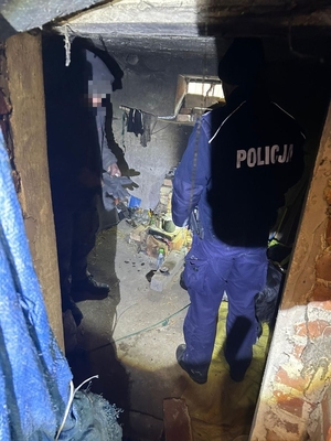 Na zdjęciu dwóch umundurowanych policjantów w pustostanie.