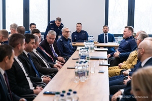 Na zdjęciu na wprost przy stole siedzą Starosta Rzeszowski Krzysztof Jarosz,  mł. insp. Marek Pietrykowski Komendant Miejski Policji w Rzeszowie, nadinsp. Andrzej Patrzałek Komendant Wojewódzki Policji w Rzeszowie, Krzysztof Stańko Wiceprezydent Miasta Rzeszowa, Sylwia Urban-Koszela szefowa Prokuratury Rejonowej dla miasta Rzeszów. Przy stołach w lewej i prawej strony zaproszeni goście i karda kierownicza rzeszowskiej komendy.